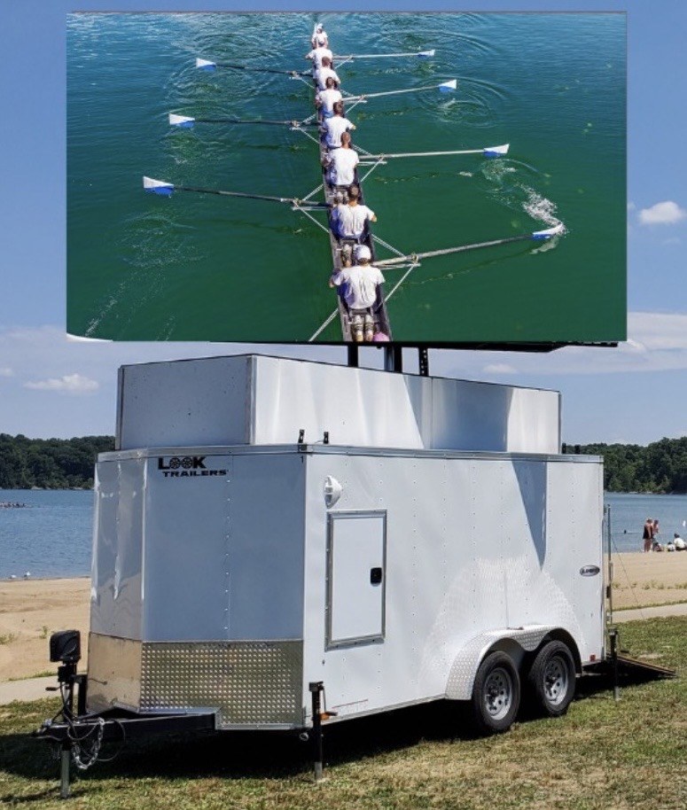 Mobile LED screen trailer at a rowing regatta in Pennsylvania showing live race coverage on a daylight-visible 13x8 ft LED screen